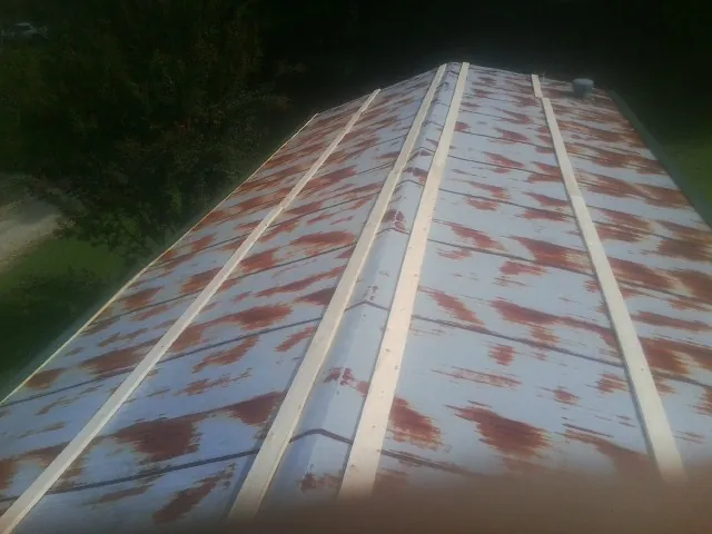 Rusted metal roof panels with new wood purlins before replacement — Storm Damage Roof Repair in Springs by Roofing Brothers