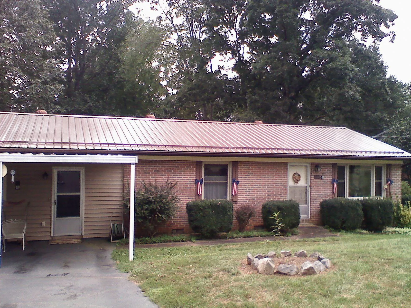Bronze metal roof and carport on a brick ranch home — Roof Repair work by our crew in Springs