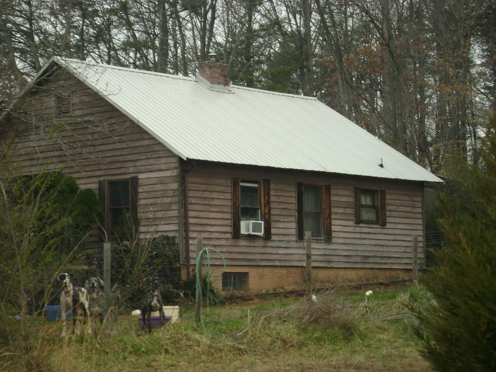 White metal roof on an old wood sided farmhouse, from a Metal Roof Installation job in Springs